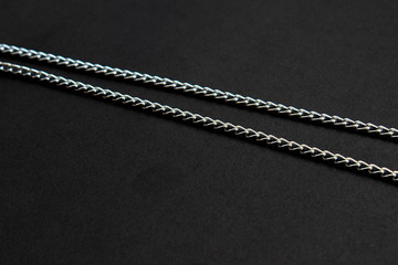 two steel chains on a black background minimalism