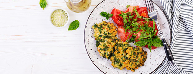 Baked steak chopped chicken fillet with spinach and a side dish of tomatoes salad. European cuisine. Dietary food.  Banner. Top view