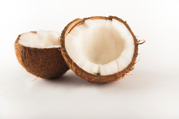 Coconut cut in half isolated on white background. Coconut milk and pulp close-up and copy space.