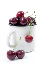 Obraz na płótnie Canvas White cup with red sweet cherry isolated on a white background..