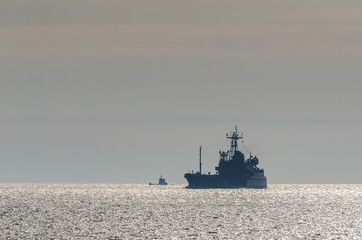 SUBMARINE AND TANKER - Warships at sea in the rays of the morning sun