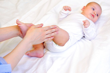Delightful massage of the feet. Charging for baby. Mom makes massage to the baby. Health and physical development of the child concept.