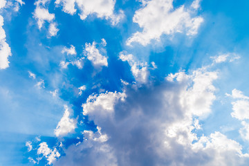 Obraz premium White clouds and sunrays on blue sky