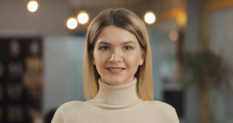 Obraz premium Portrait of young successful businesswoman looking at camera standing in office workspace.