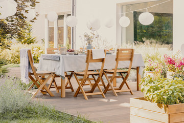Outdoor dining room with wooden garden furniture set with table and chairs