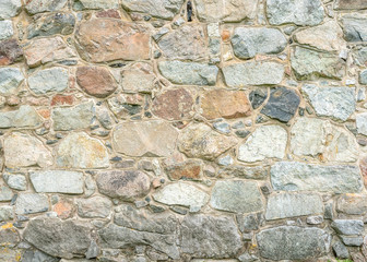 Stone wall texture. Colorful granite stone background. Old Vintage Stone Wall of Historical Medieval Castle in North Europe. 