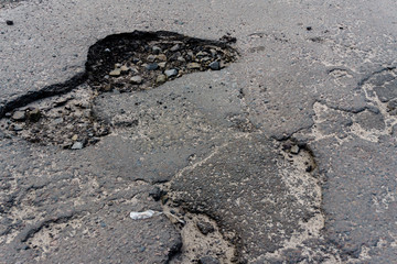 Dangerous asphalt road with big holes destroyed