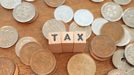 Wooden Text Block of Tax and Pile of Coins