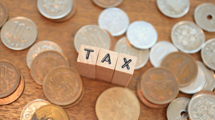 Wooden Text Block of Tax and Pile of Coins