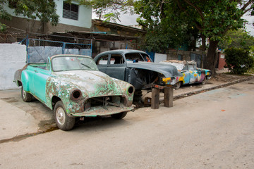 Obraz na płótnie Canvas Classic cars under repair in the middle of a street in Havana