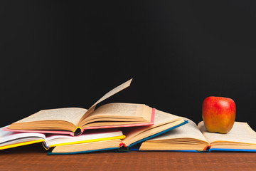 Back to school concept. Blackboard with books and apple on wooden desk