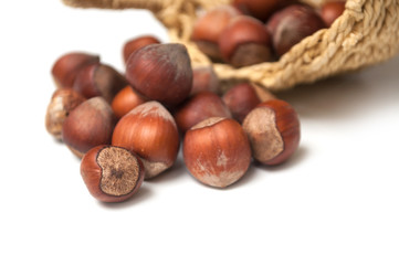 closeup of nuts falling from basket on white background