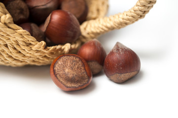 closeup of nuts falling from basket on white background