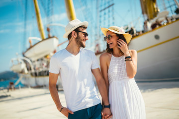 Young beautiful tourist couple enjoying summer holiday on the seaside