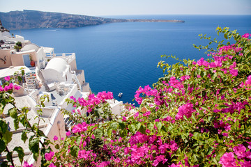 beautiful Oia town on Santorini island, Greece. Traditional white architecture and greek orthodox churches with blue domes over the Caldera, Aegean sea. Scenic travel background