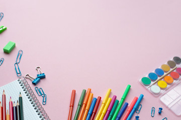Notepad with stationary objects on pink background. Place for your text