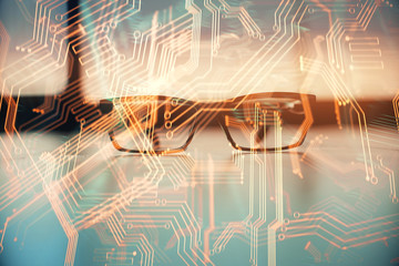 Tech theme hologram with glasses on the table background. Technology concept. Double exposure.