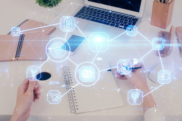 Social network theme hologram over hands taking notes background. Concept of global international people connect. Double exposure