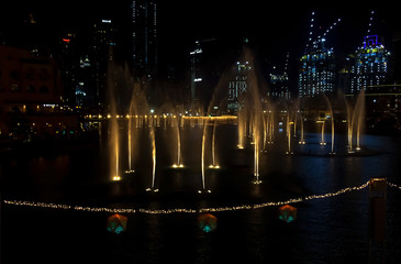 Dancing fountains in focus night background selective focus. Shallow depth of field.