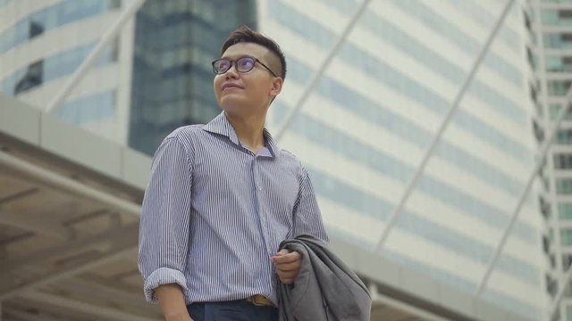 Portrait handsome businessman standing looking around urban city. Slow motion low angle shoot.