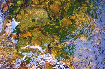 ripple current of the stream with stones under the surface of the water