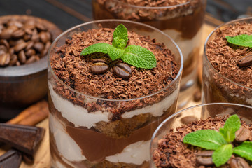 Classic tiramisu dessert in a glass on wooden background