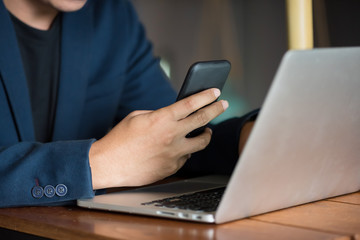 Fototapeta premium Asian business man working with his smartphone in coffee shop in selective focus.