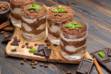 Classic tiramisu dessert in a glass on wooden background