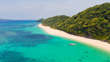 Puka Shell Beach. Wide tropical beach with white sand. Beautiful white beach and azure water on Boracay island, Philippines, top view. Tourists relax on the beach.