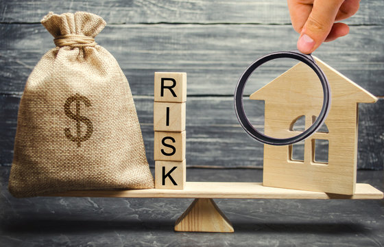 Money Bag, Blocks With The Word Risk And A Wooden House On The Scales. The Concept Of Losing Money When Investing In Real Estate. Risks Of Losing A Home Or Housing For Non-payment. Property Insurance