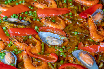 Spanish seafood paella in fry pan with mussels, shrimps and vegetables. Seafood paella background, closeup, traditional spanish rice dish