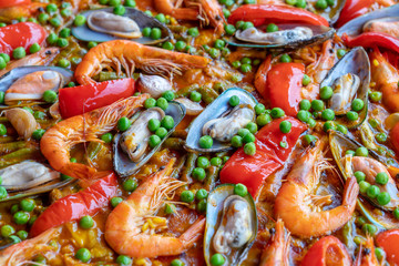 Spanish seafood paella in fry pan with mussels, shrimps and vegetables. Seafood paella background, closeup, traditional spanish rice dish