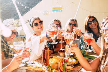 Cheerful group of happy female people clinking and toasting together with friendship and happiness...