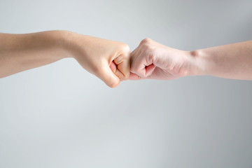 Hand symbol of two fists crash together on white background.