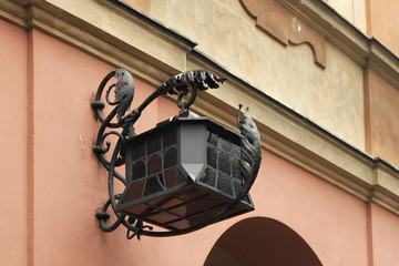 Ancient streetlight on the one of old buildings in historical center of Warsaw.