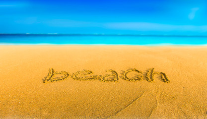The yellow sand on the beach blue sea and the inscription beach
