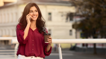 Fototapeta premium Young manager having break, drinking coffee and talking on phone