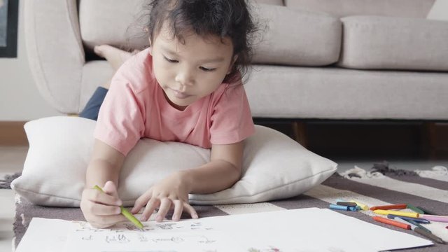 Asian girl drawing and Happily coloring in her home