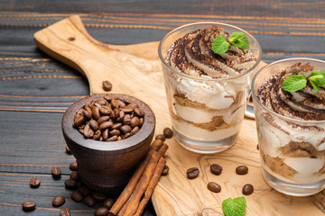 Classic tiramisu dessert in a glass on wooden background