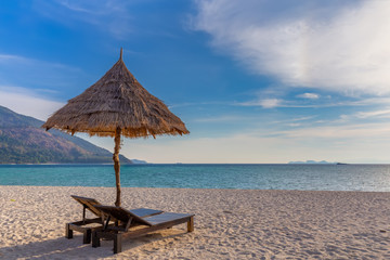 Beach chairs, umbrella and palms on the beautiful beach for holidays and relaxation at Koh Lipe island, Thailand