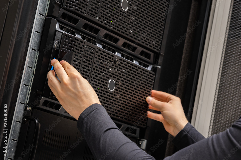 Wall mural close-up of hands of it consultant installing servers in rack at datacenter