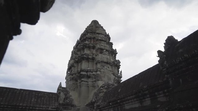 Walking out to get a view reveal of the central shrine at Angkor Wat temple on a cloudy day.