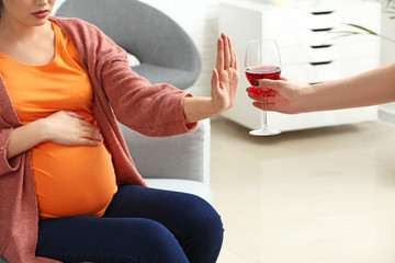 Pregnant woman rejecting alcohol at home