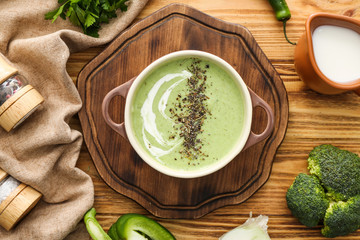 Pot of tasty cream soup on wooden table