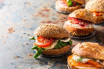 Italian Caprese sandwiches with fresh tomatoes, mozzarella cheese and lamb's lettuce, multigrain bun. Healthy food concept with copy space