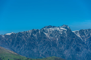 View of the snowy mountain peak against the blue sky, Queenstown, New Zealand. Copy space for text.
