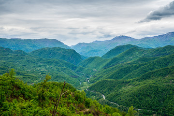 Fototapeta na wymiar Montenegro, Endless view over green tree covered mountains forming moraca canyon nature landscape from above