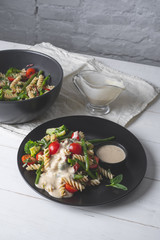 Chef cooking pasta with vegetables - traditional Italian salad dish,