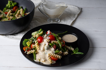 Chef cooking pasta with vegetables - traditional Italian salad dish,