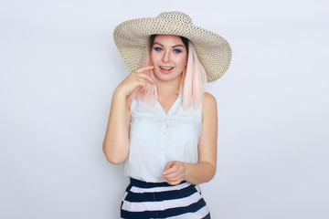 Young blonde woman with big white summer hat